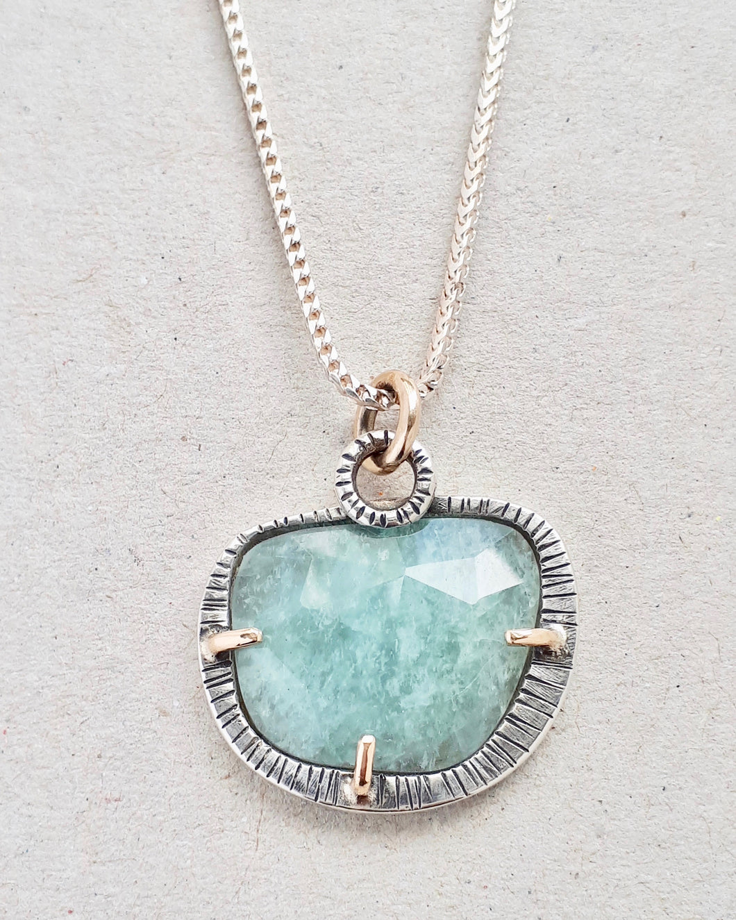 rose cut aquamarine in sterling silver and 10k gold pendant with sterling silver chain. front close up view.