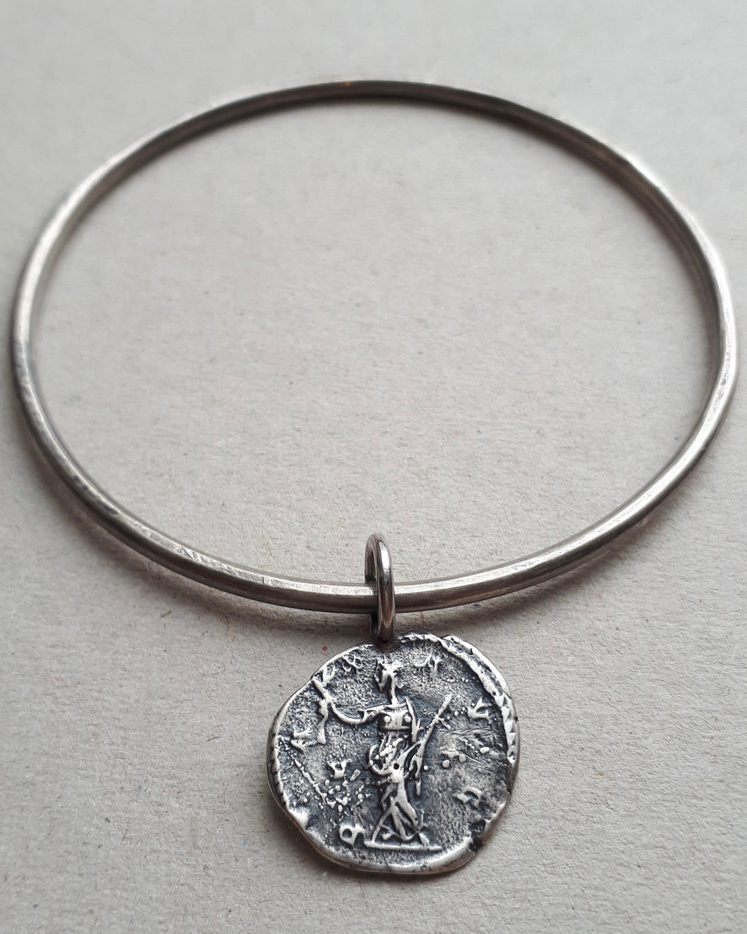Oxidized sterling silver bangle featuring an ancient Roman coin Pax, the goddess of peace and harmony.
