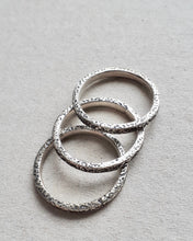Load image into Gallery viewer, Top view of three sterling silver concrete textured rings.
